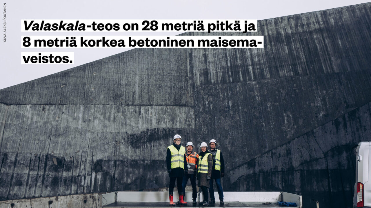 Valaskala-teos on 28 metriä pitkä ja 8 metriä korkea betoninen maisemaveistos. Kuvassa suunnittelu- ja rakennustiimi seisoo valtavan betonisen veistoksen edessä.